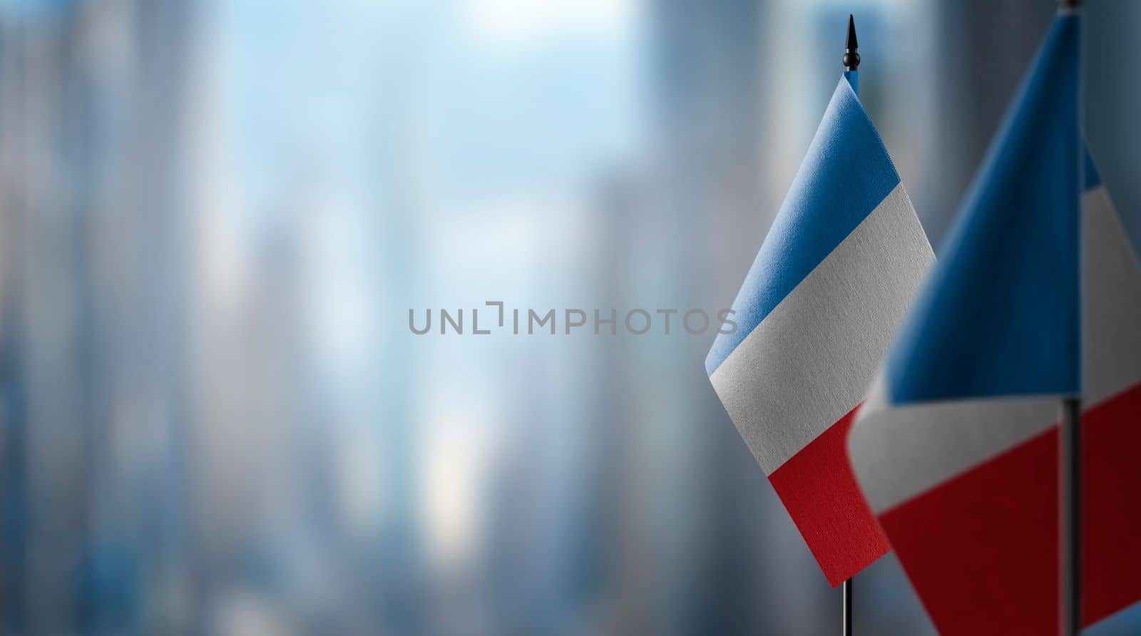 Small flags of the France on an abstract blurry background by butenkow