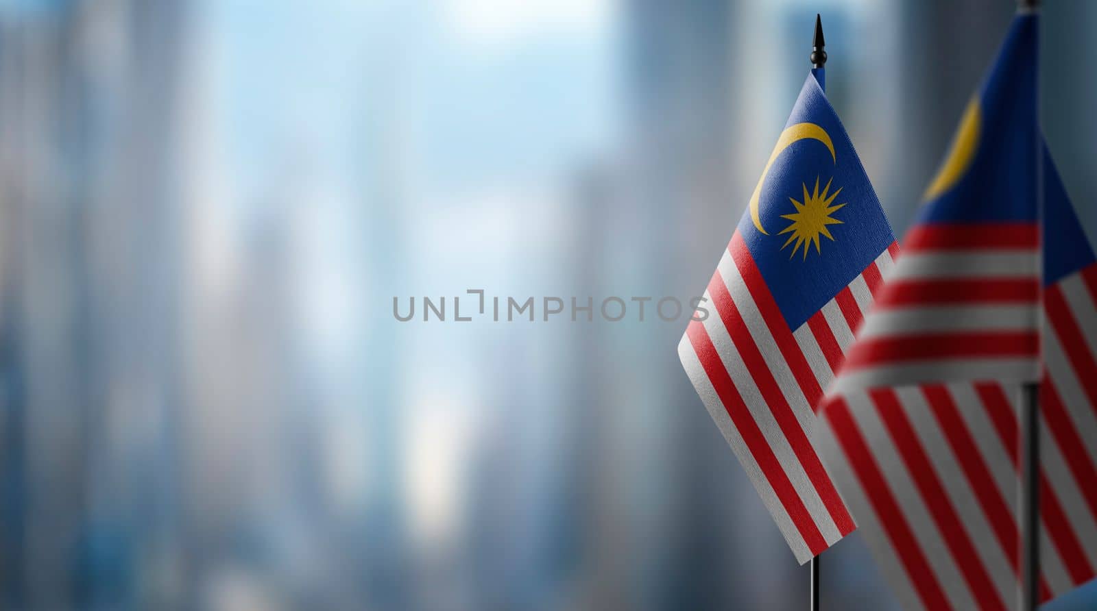 Small flags of the Malaysia on an abstract blurry background.