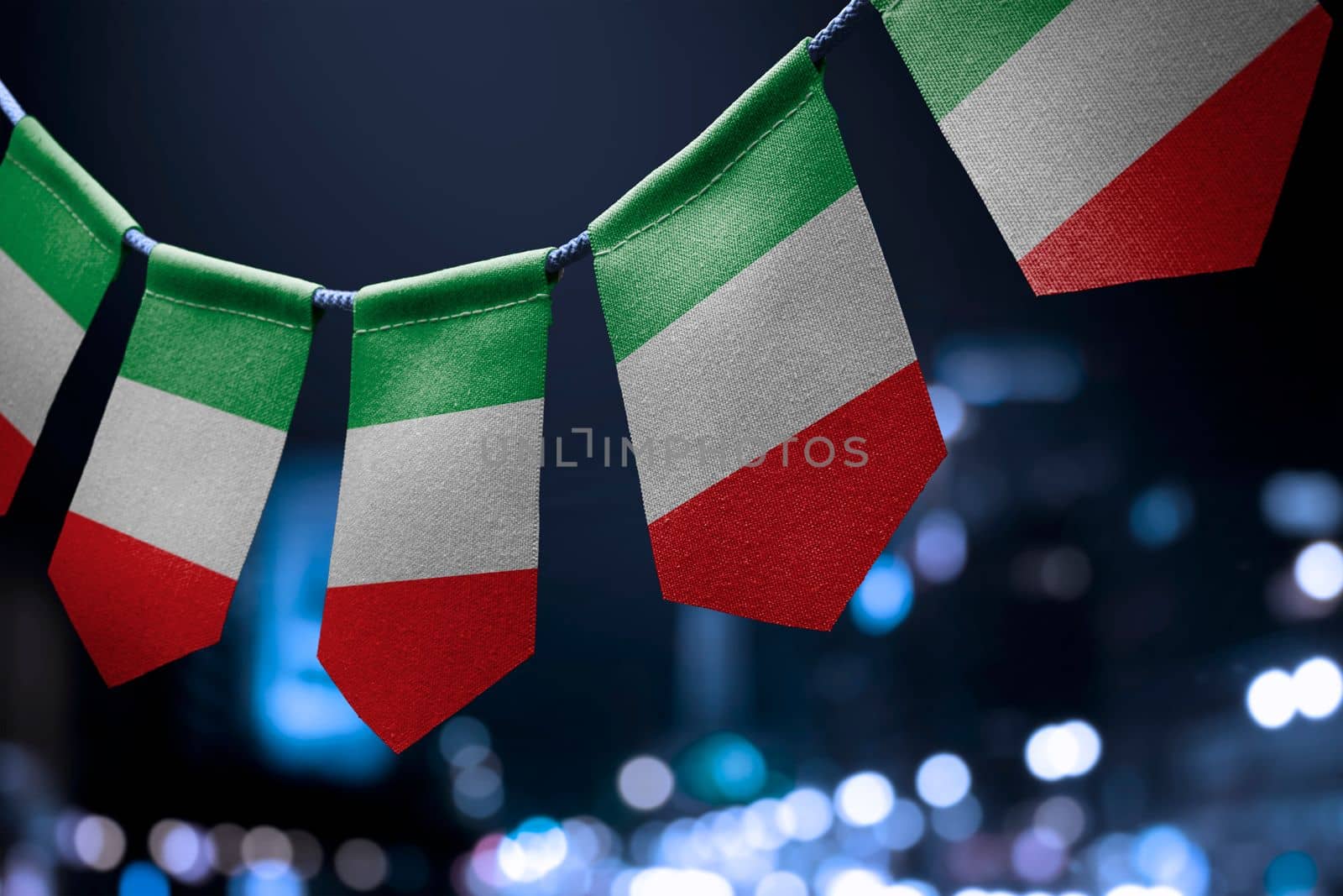 A garland of Italy national flags on an abstract blurred background by butenkow