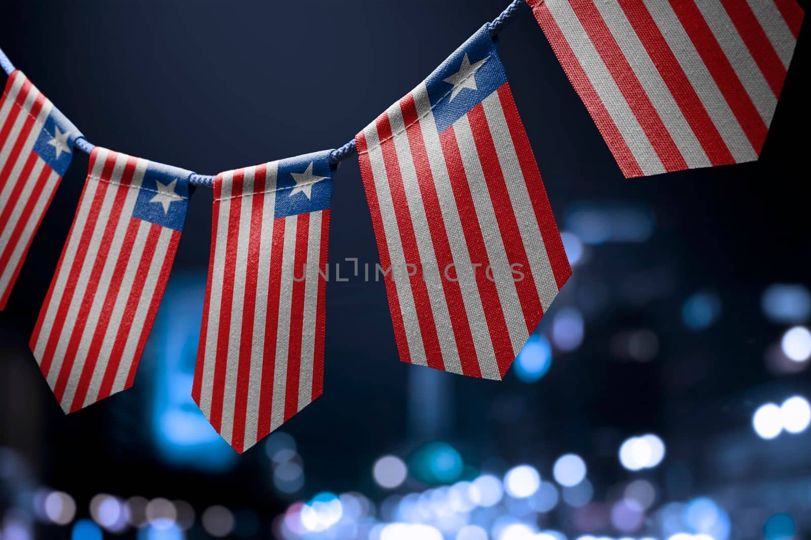 A garland of Liberia national flags on an abstract blurred background.