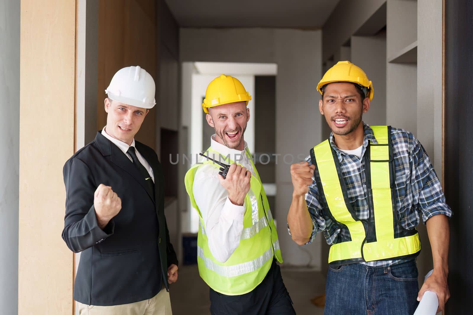 Portrait American and Asian professional Engineer celebrating while project success. architectural plan, engineer sketching a construction concept