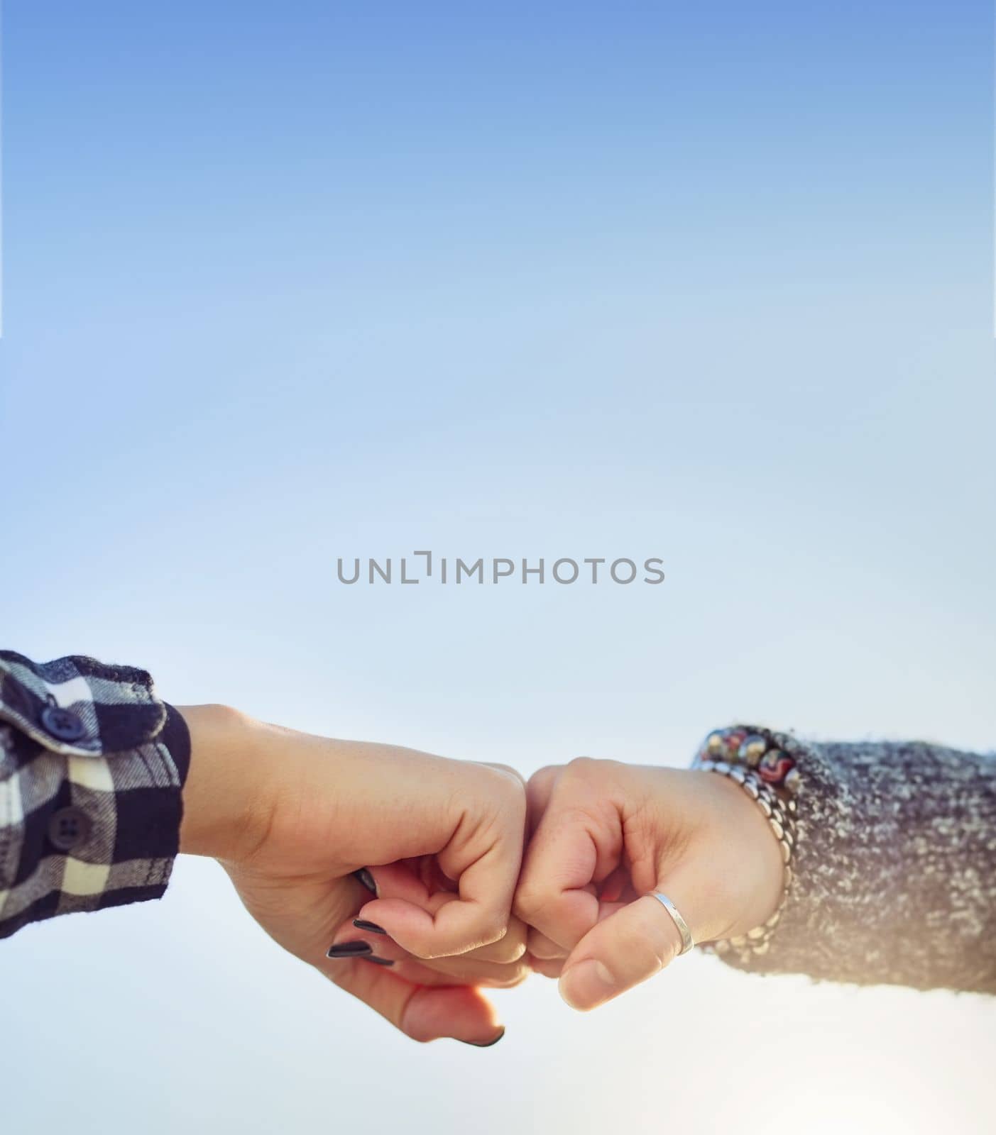 For life. two unrecognizable women fist bumping outdoors