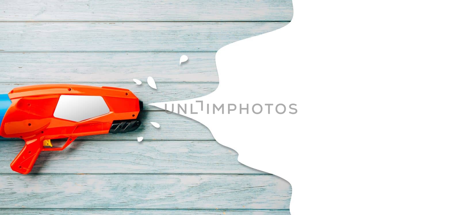 Happy songkran day festival at Thailand. water gun shoot water splash drawing empty space for text isolated on blue wooden background, traditional Thai New Year, Web banner design