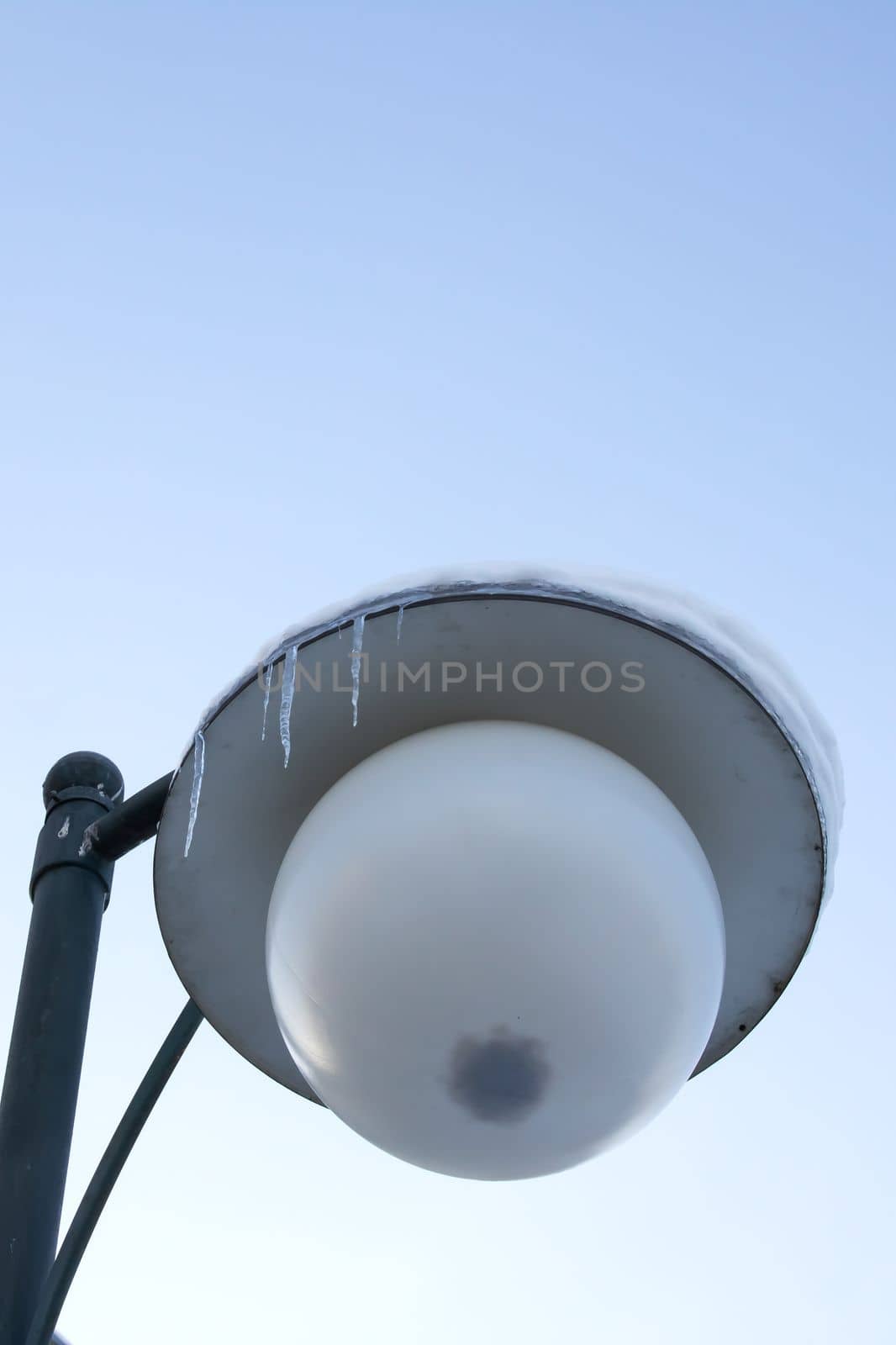 Street lantern under the snow and ice close up