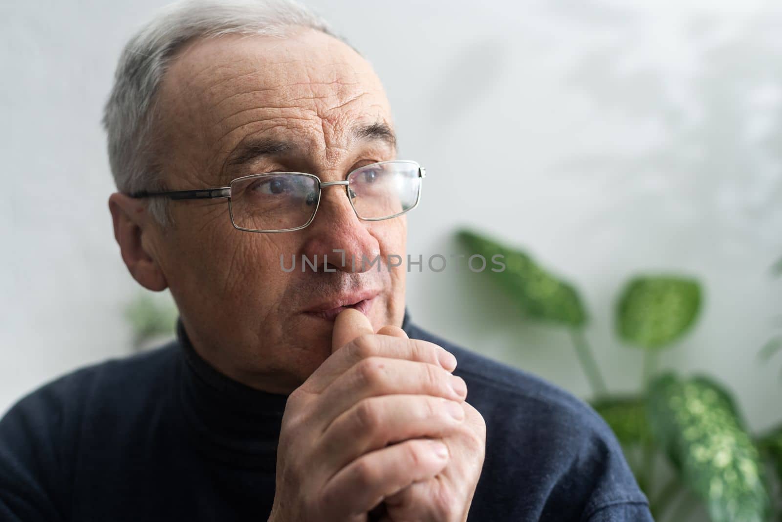 Elderly caucasian man with interlocked fingers.