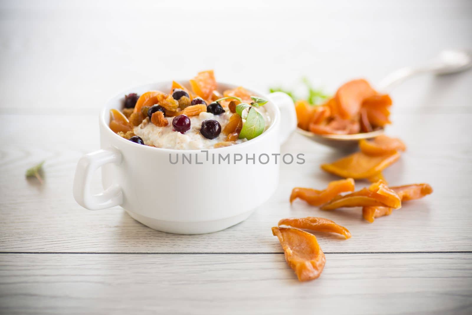 oatmeal with candied fruits, raisins in a plate by Rawlik