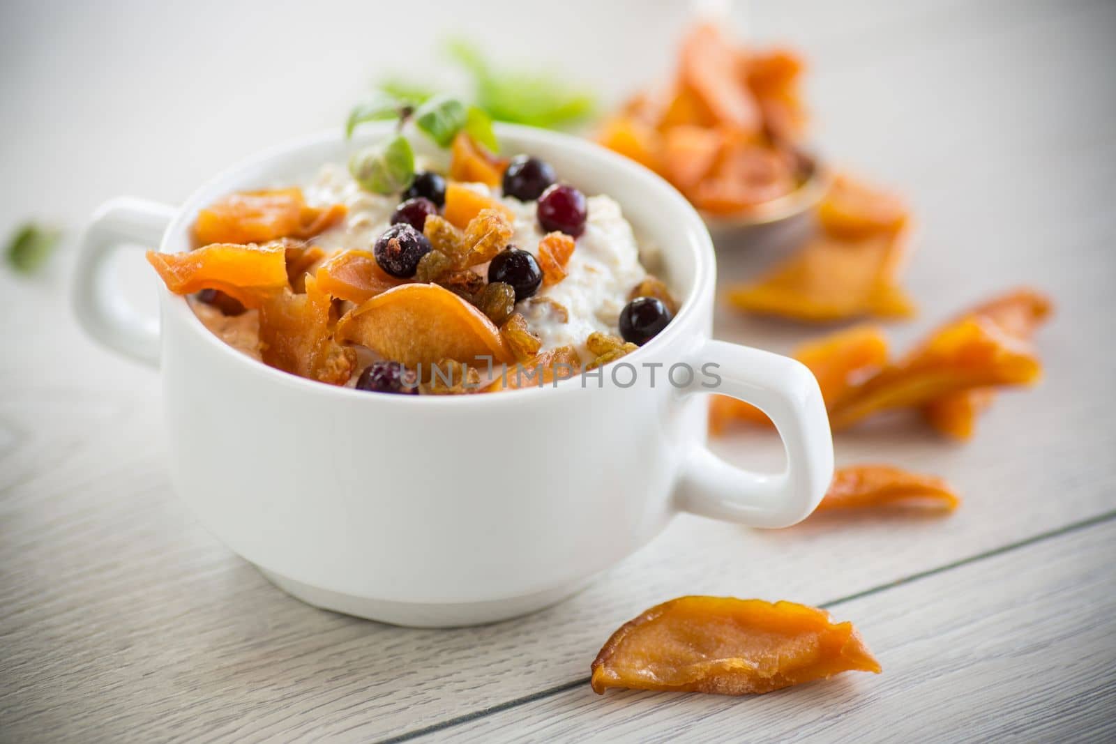 oatmeal with candied fruits, raisins in a plate by Rawlik