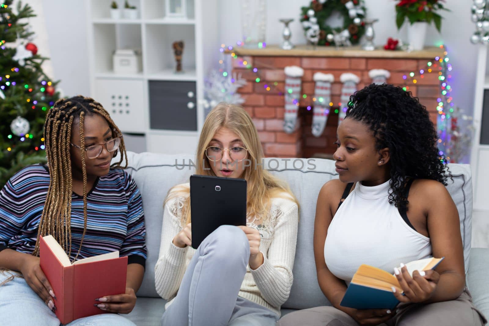 Amazing information read by a student in a tablet on the website. Fellow students from Africa and Europe. Female students with glasses.