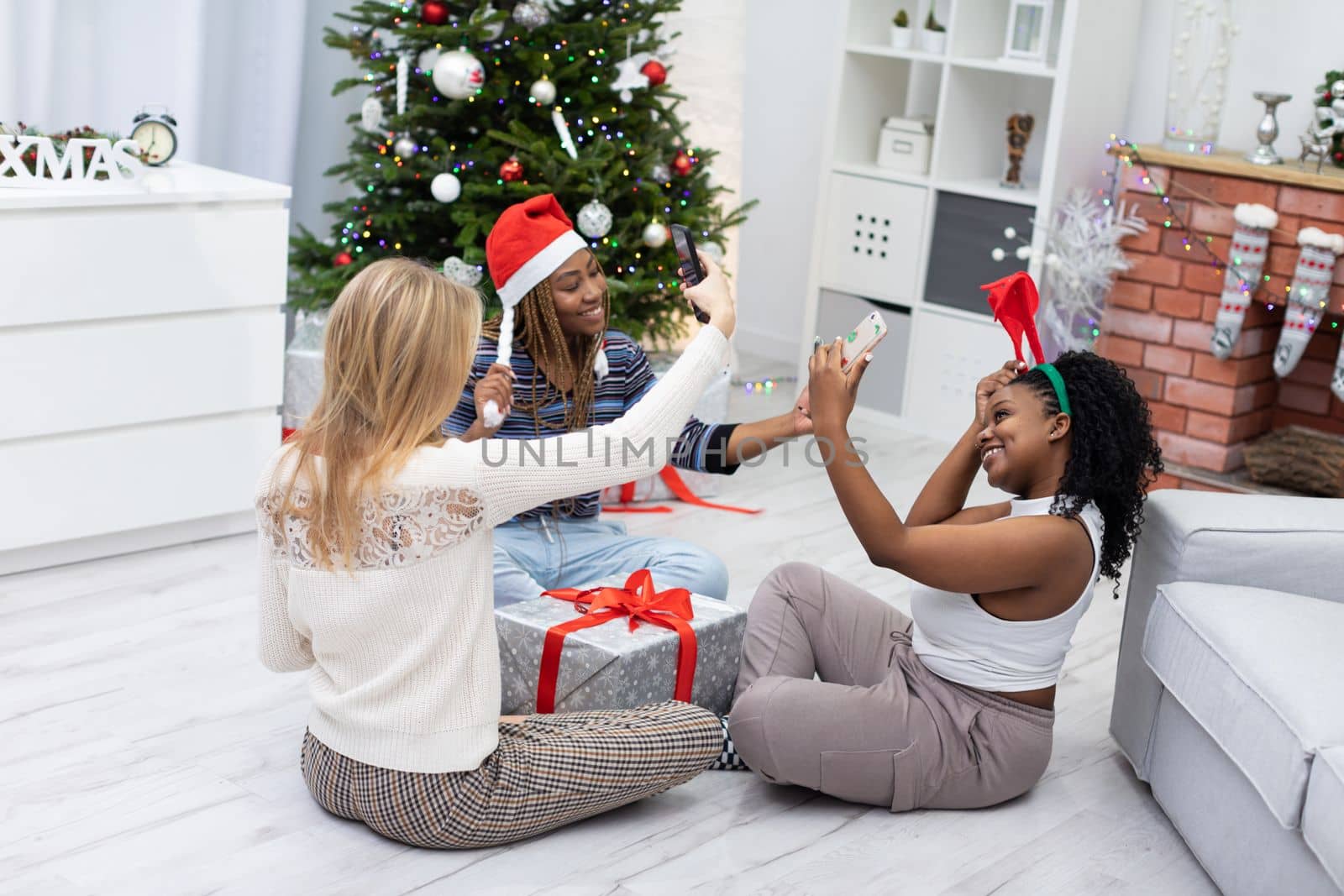 Three virgins celebrate Christmas together. Joyful photos taken with a smartphone. Selfie is a keepsake for selfies and on social media.
