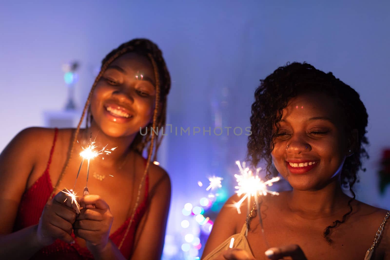 Burning cold fires. Two smiling African women play with burning cold fires. Christmas fun.