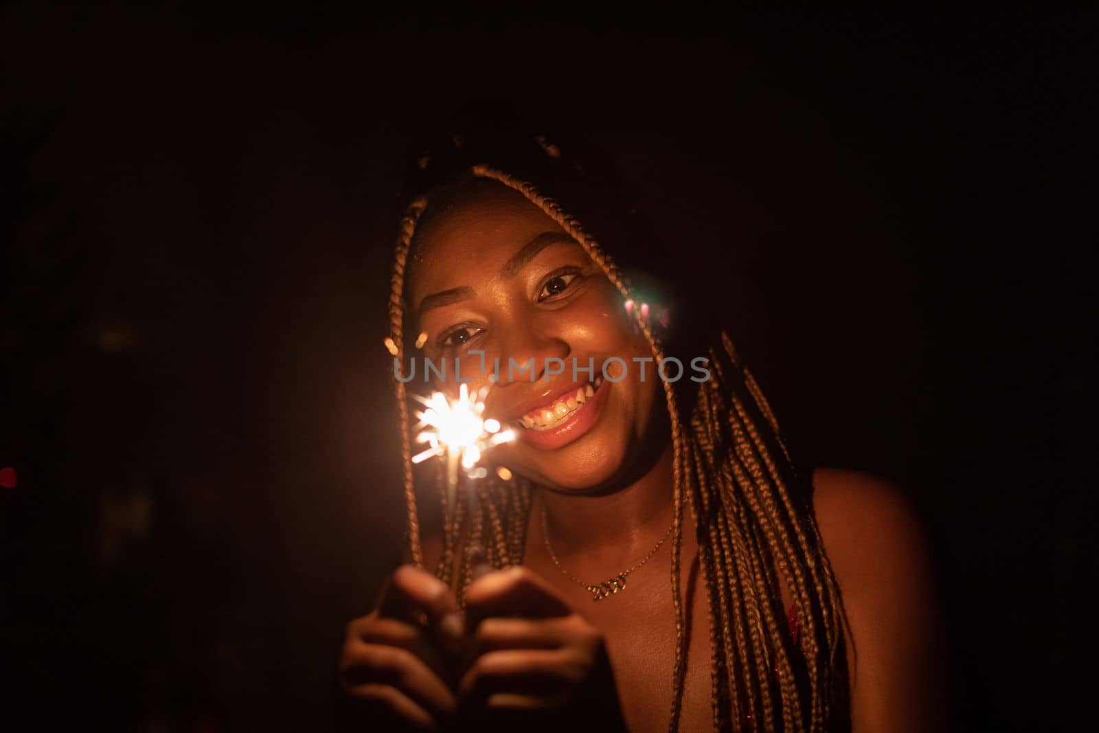 An attractive dark-skinned girl holds burning cold fires in her hand. by fotodrobik