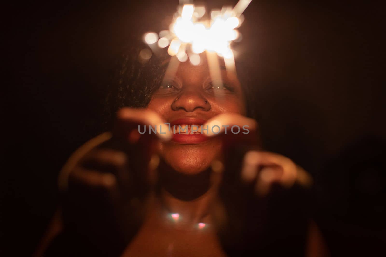 The inexhaustible joy of burning cold fires and the coming new year. Happiness and joy are drawn on the face of a dark-skinned girl.