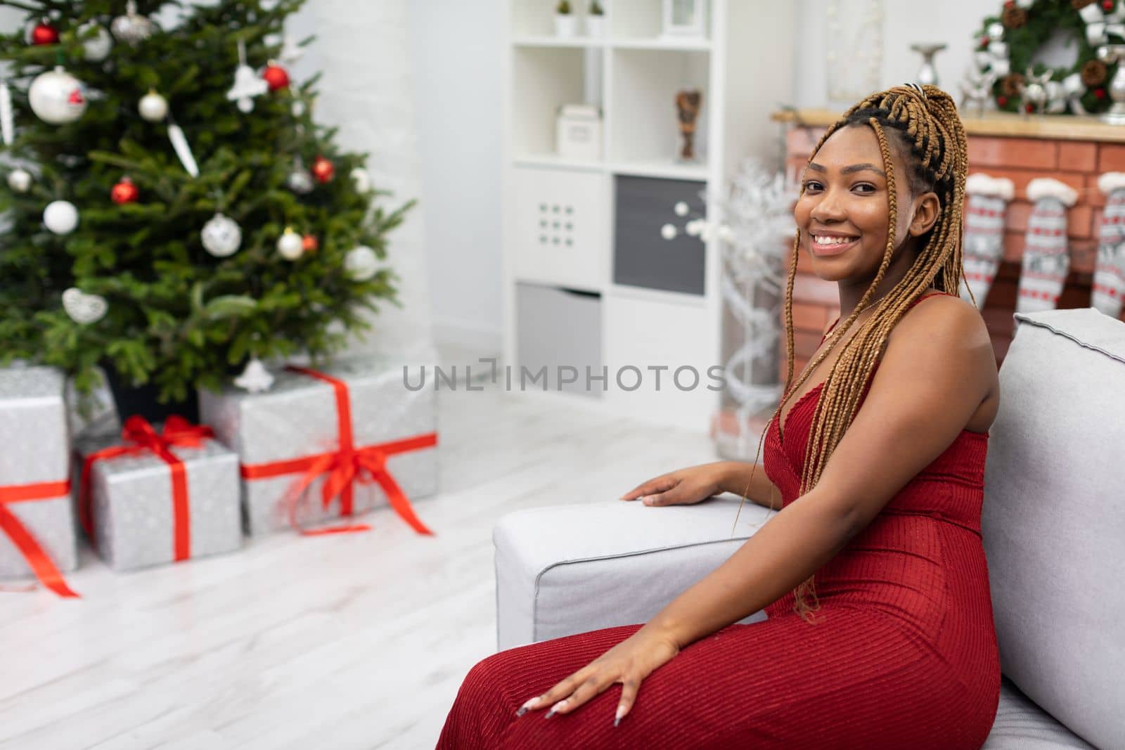 Gifts decorated with a red bow. An African woman waits for invited guests. A few hours before Christmas Eve. Christmas decoration.