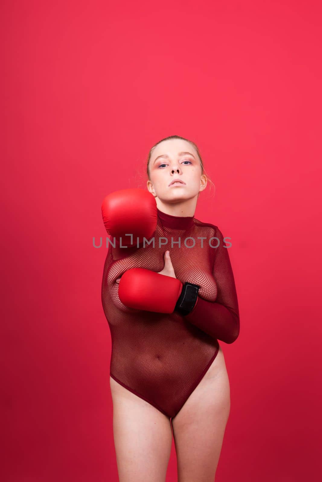 Boxer, seductive confident female boxer with gloves studio, sporty woman posing looking to camera.