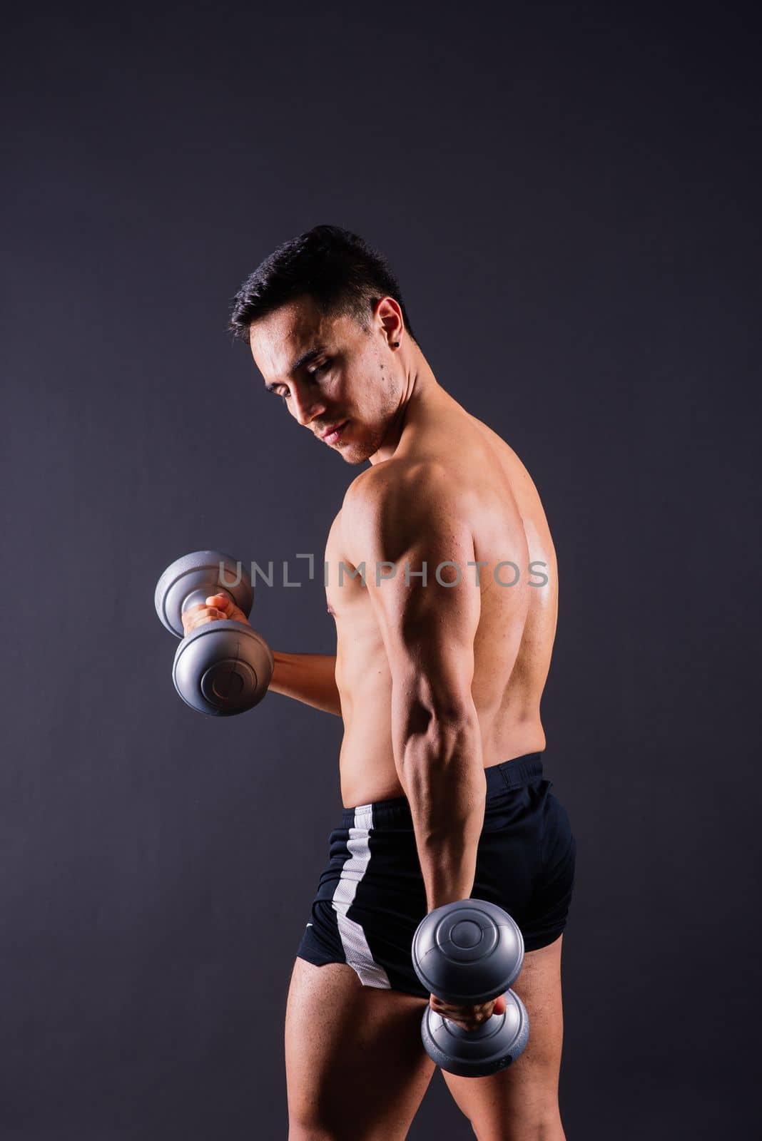 Portrait young fitness sporty strong man bare-chested muscular sportsman isolated on grey dark. by Zelenin