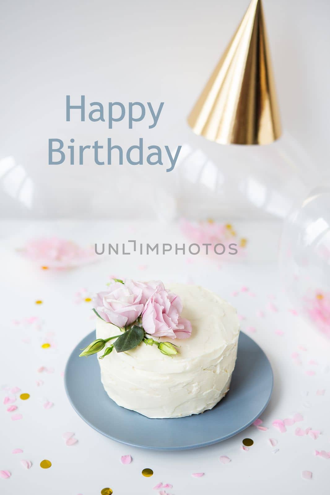 Very beautiful small white cake decorated with natural flowers eustoma on the background candy, balloons, cap. Happy birthday lettering