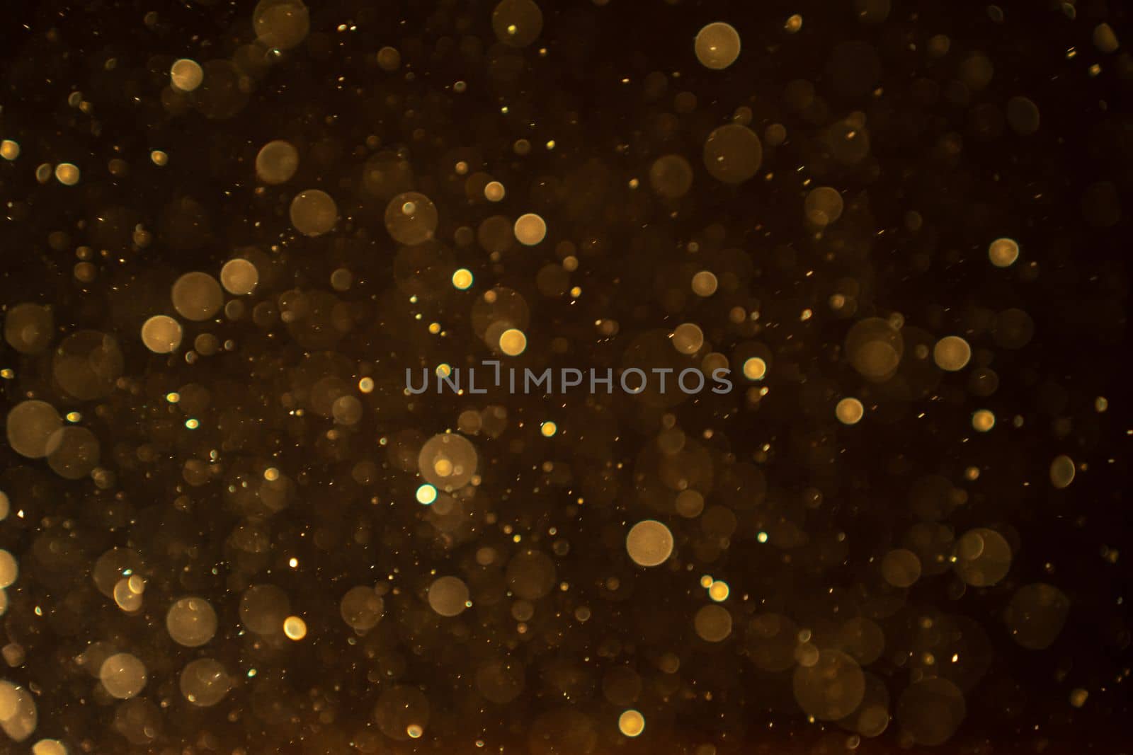 Organic bokeh dust particles floating on light beam on black background. Glittering sparkling by PaulCarr