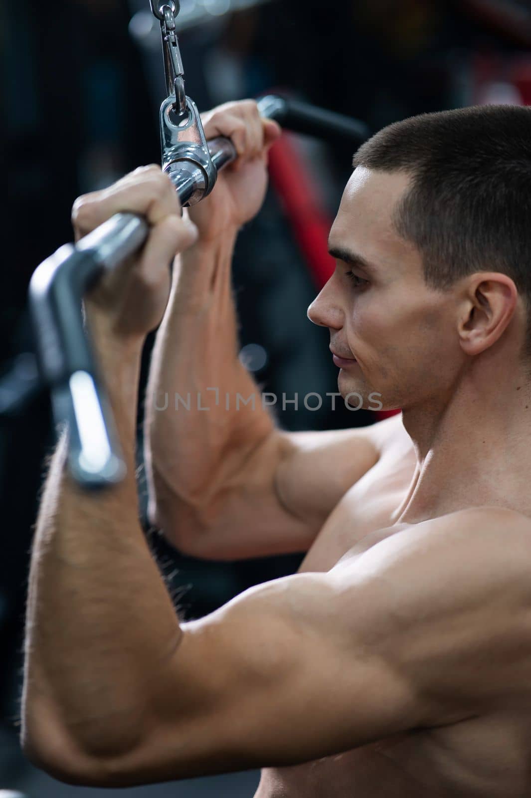 A man does a chest pulldown in the gym