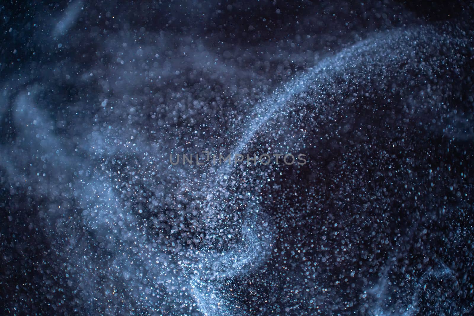 Dust particles cloud generating abstract shape on black background with copy space for text. by PaulCarr