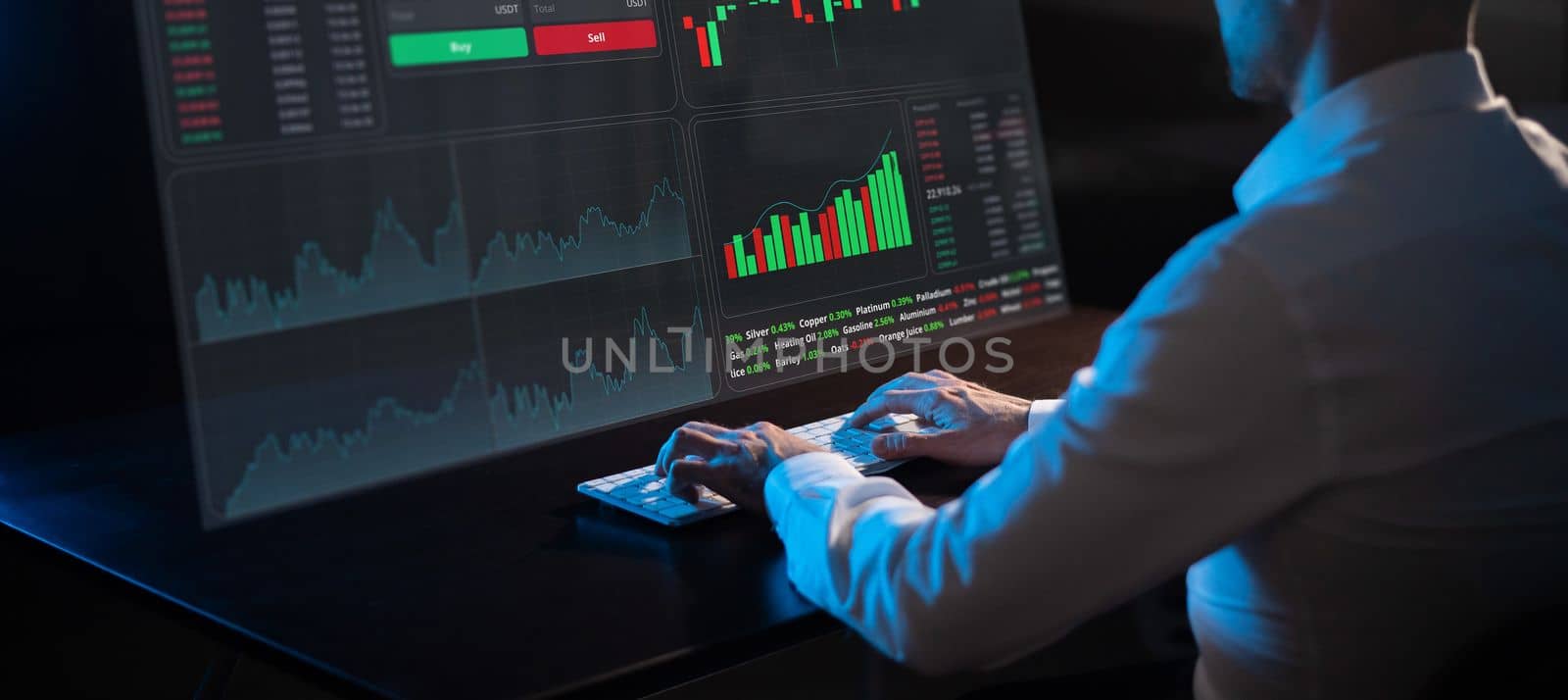 Caucasian man sits in the dark in front of a virtual screen. Stock exchange charts