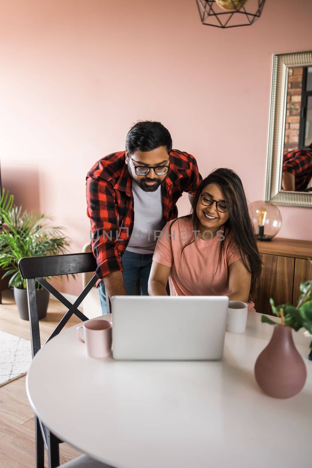 technology, remote job and lifestyle concept - happy indian man in glasses with laptop computer working at home office