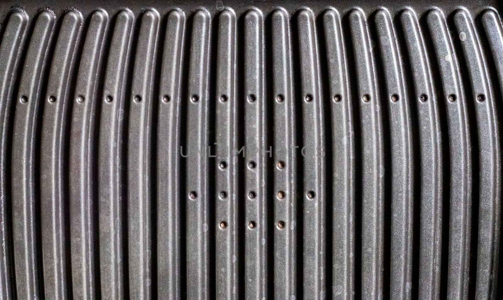 Black electric grill grate, textured background. The surface of the electric grill. Pollution of the surface of the electric stove. Close-up of a home electric grill, in the kitchen. BBQ