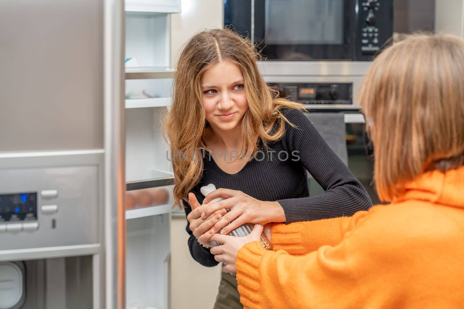 the children are fighting over the sweets in the fridge. High quality photo