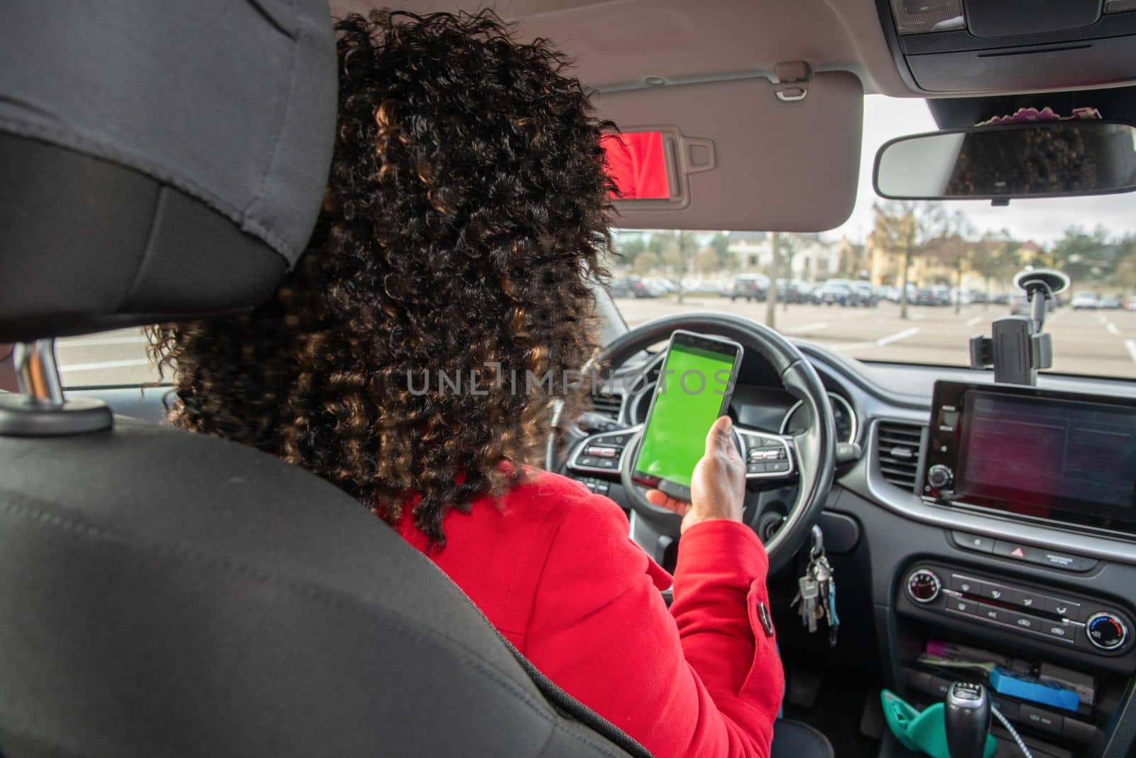 Satisfied young african american woman video chatting in car with someone on mobile phone with green screen in parked car, using technology, High quality photo
