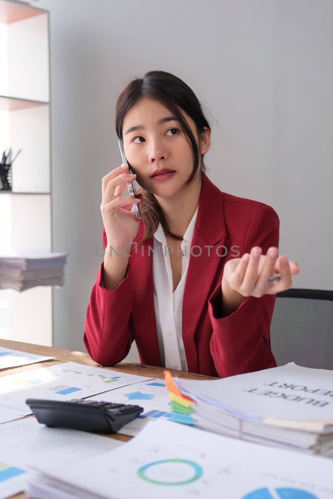 Businesswoman consultant talking on phone and calculating finance. freelance, tax, accounting, statistics and analytic research concept.