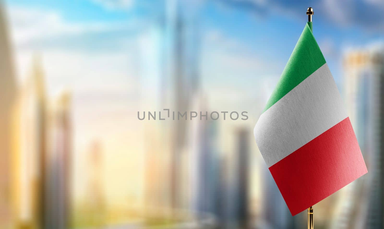 Small flags of the Italy on an abstract blurry background.