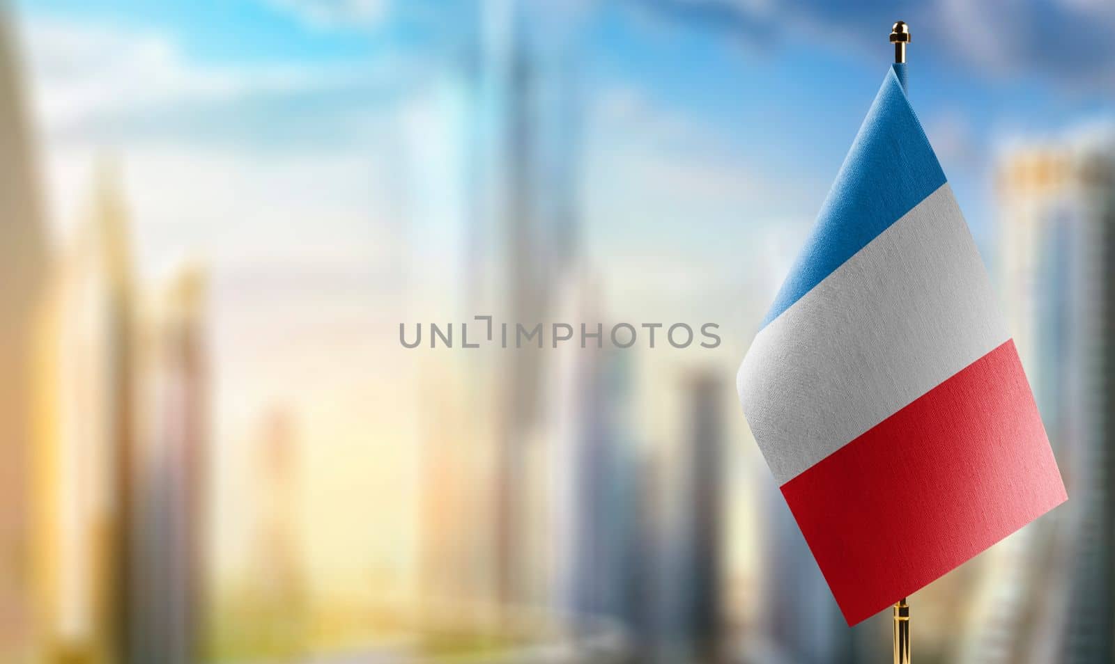 Small flags of the France on an abstract blurry background.