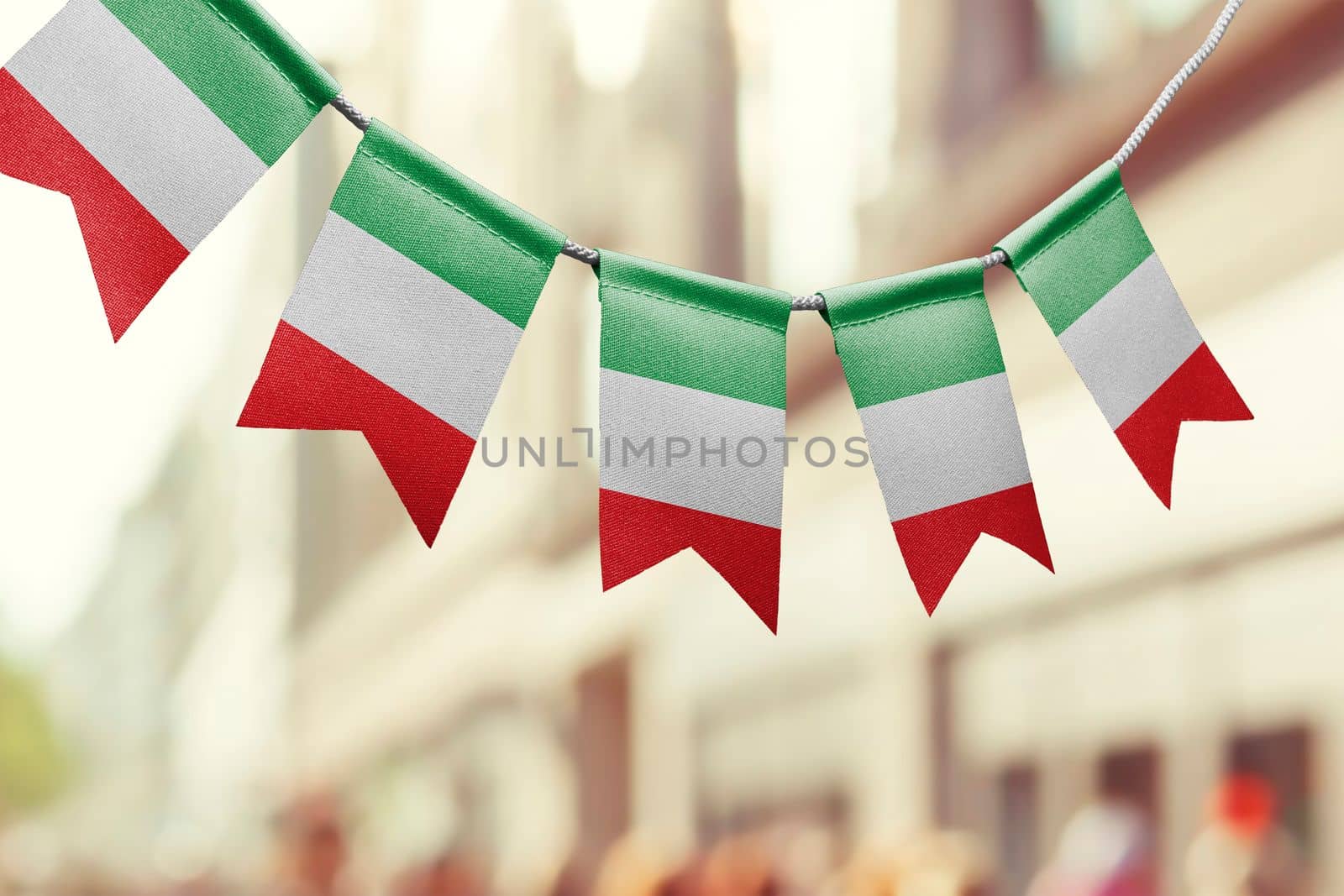A garland of Italy national flags on an abstract blurred background.