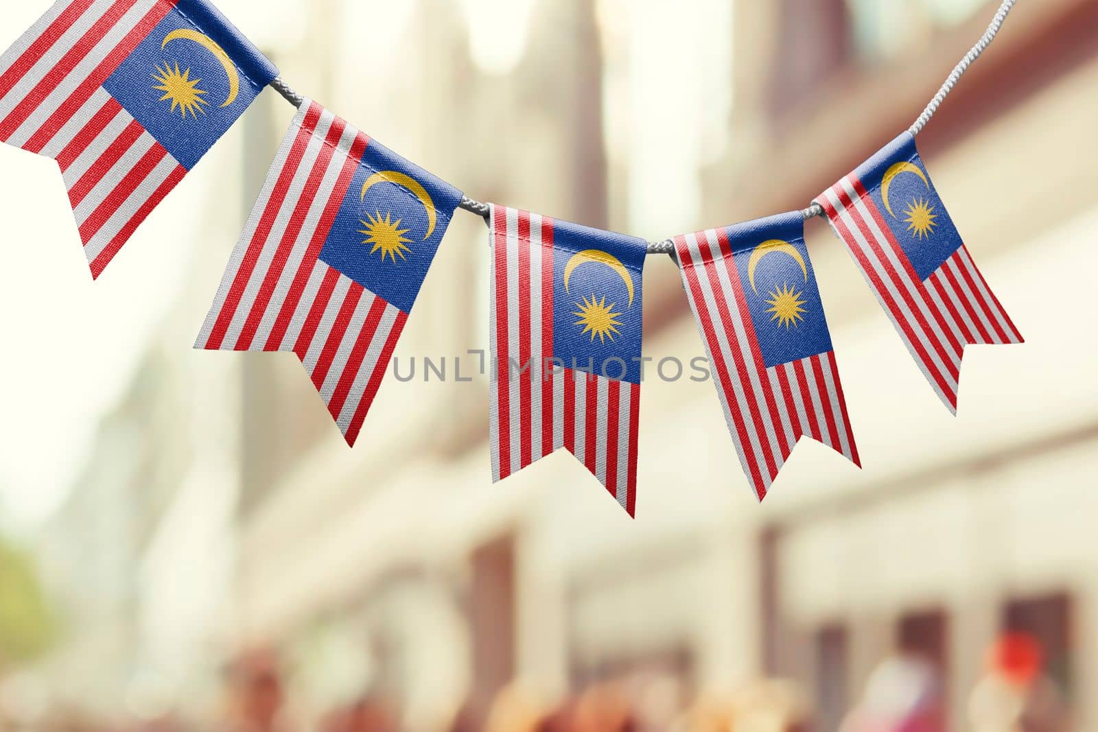 A garland of Malaysia national flags on an abstract blurred background.