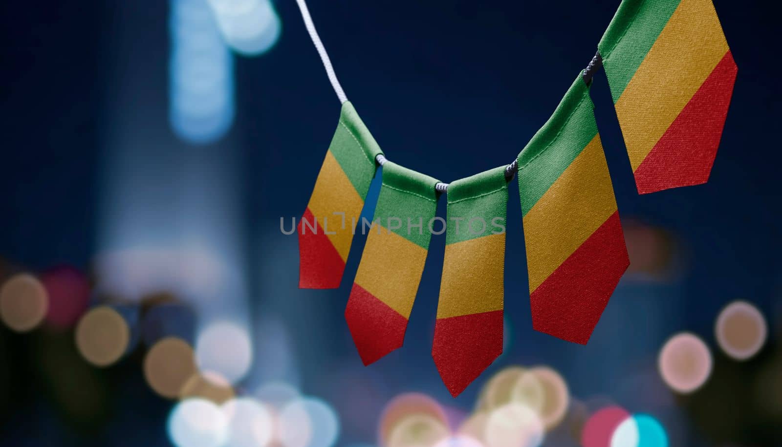 A garland of Mali national flags on an abstract blurred background by butenkow
