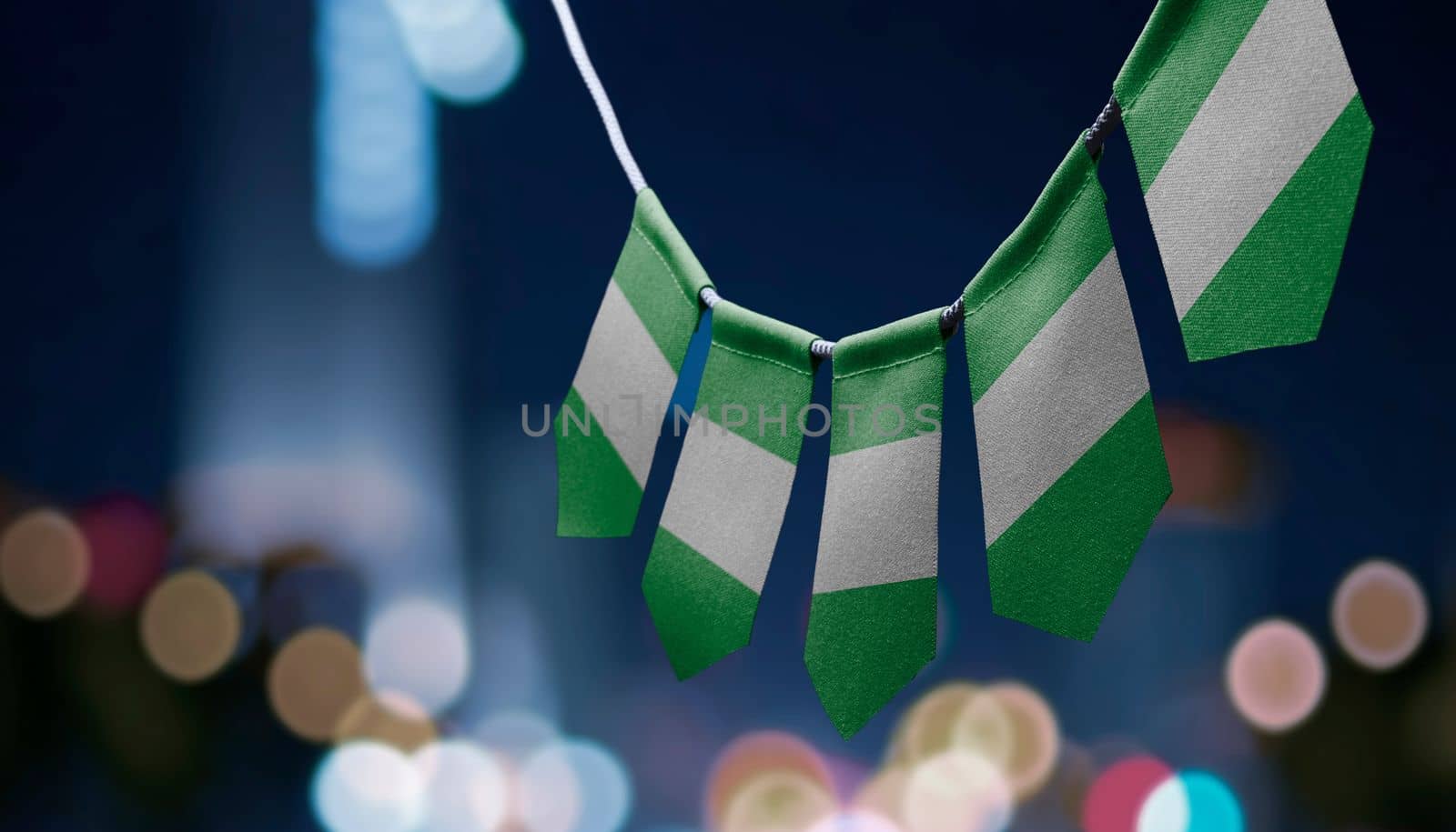 A garland of Nigeria national flags on an abstract blurred background.
