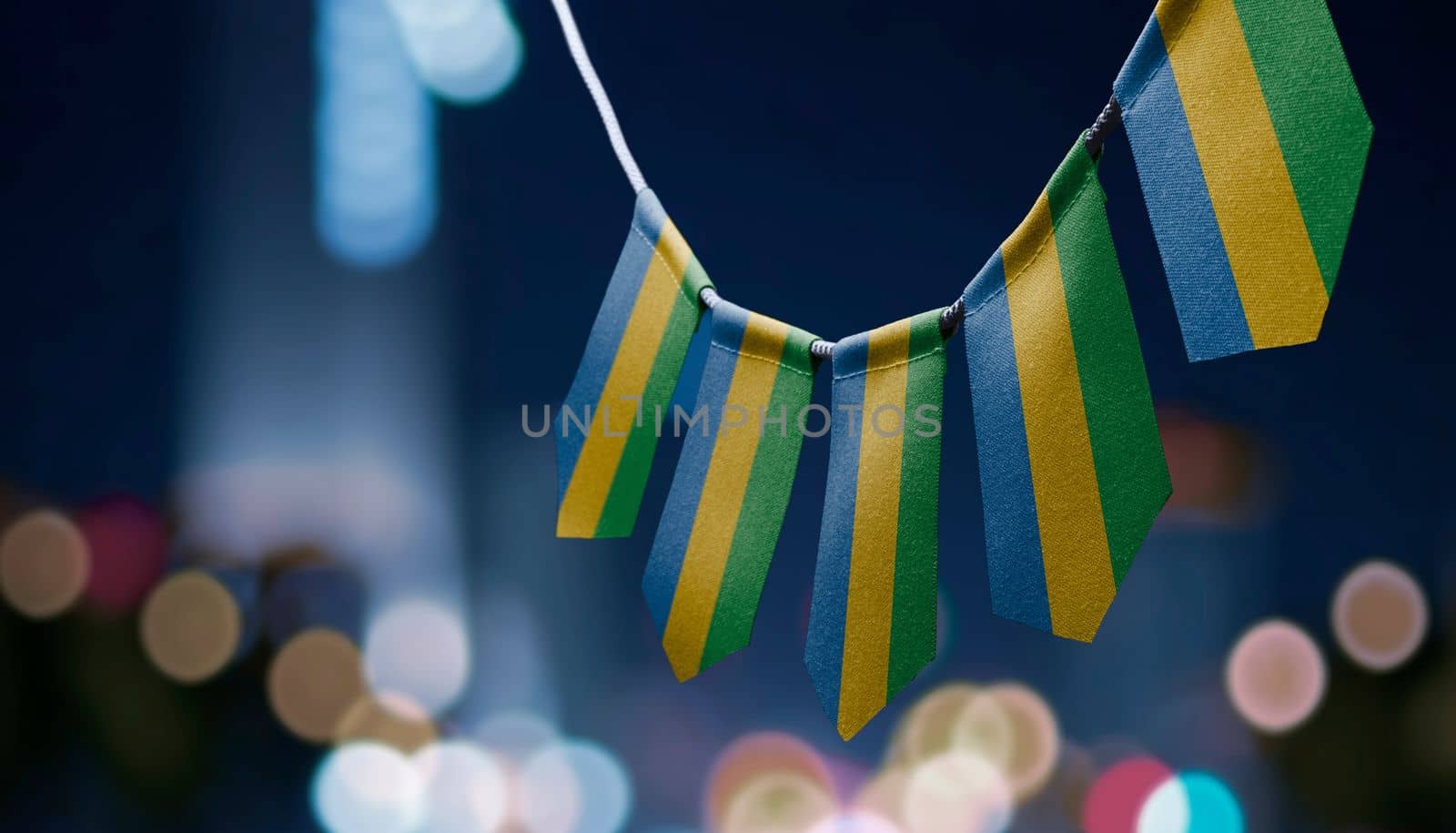 A garland of Gabon national flags on an abstract blurred background.