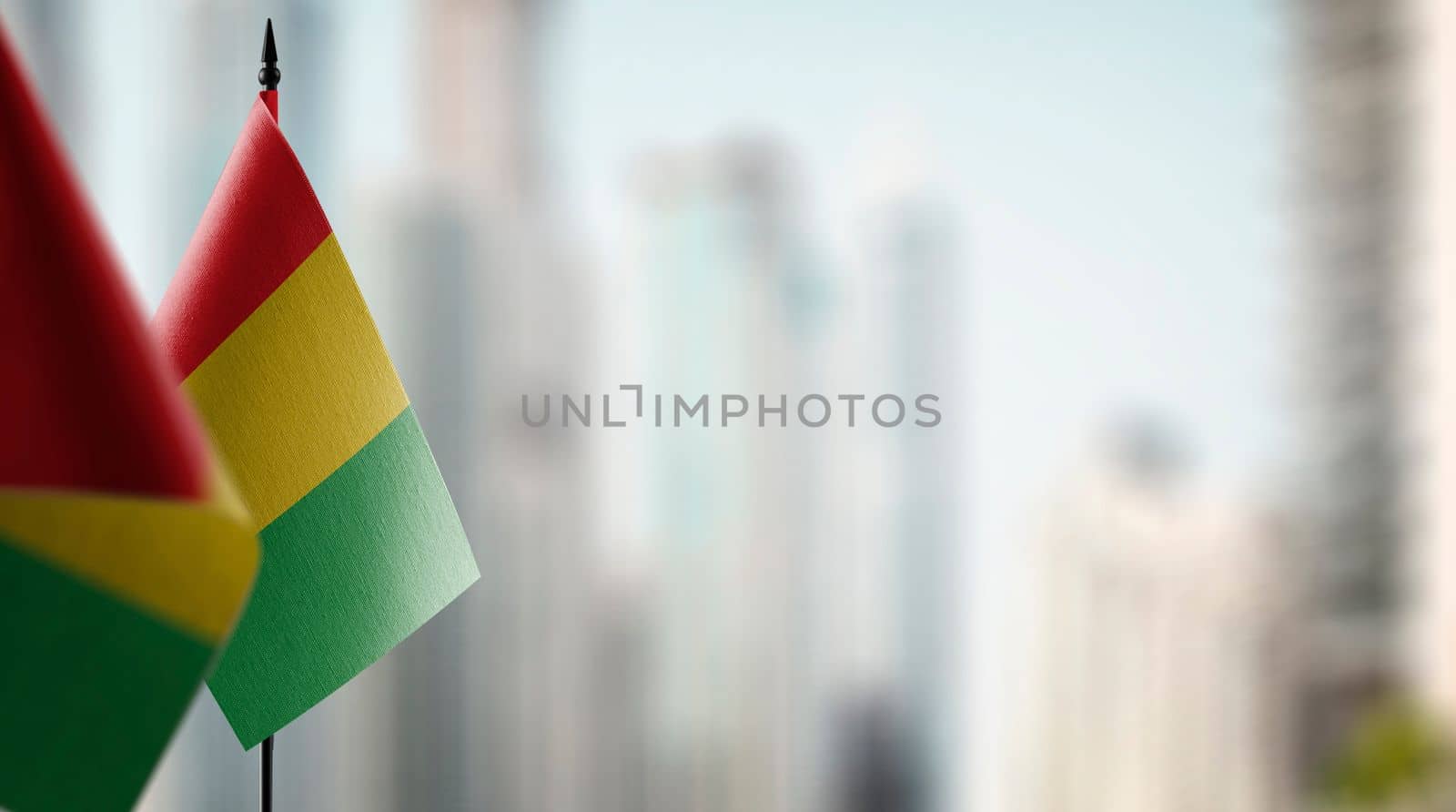 Small flags of the Guinea on an abstract blurry background by butenkow
