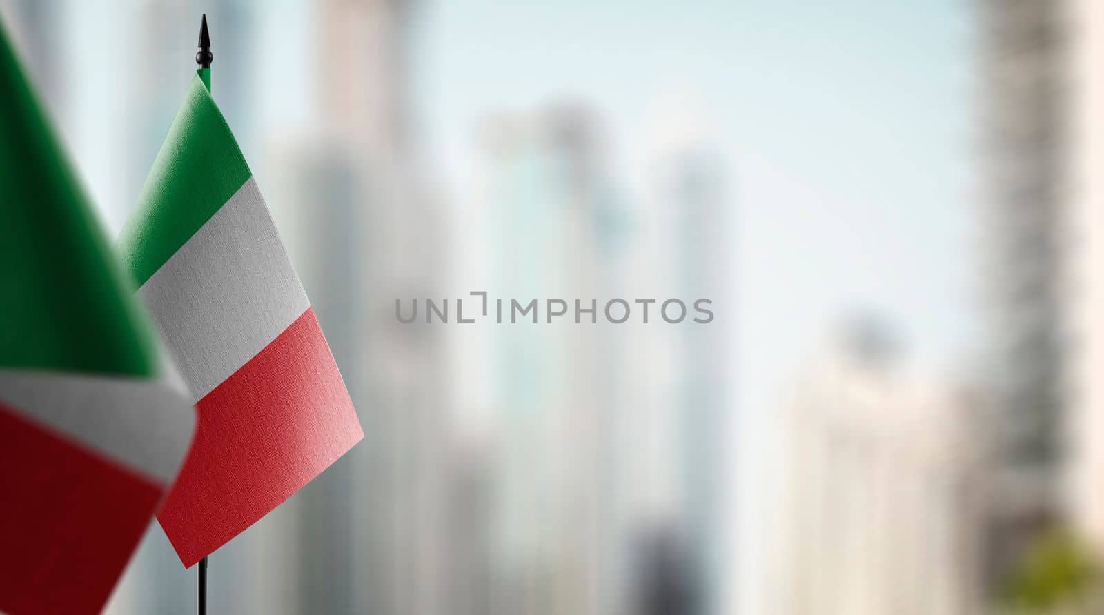 Small flags of the Italy on an abstract blurry background.