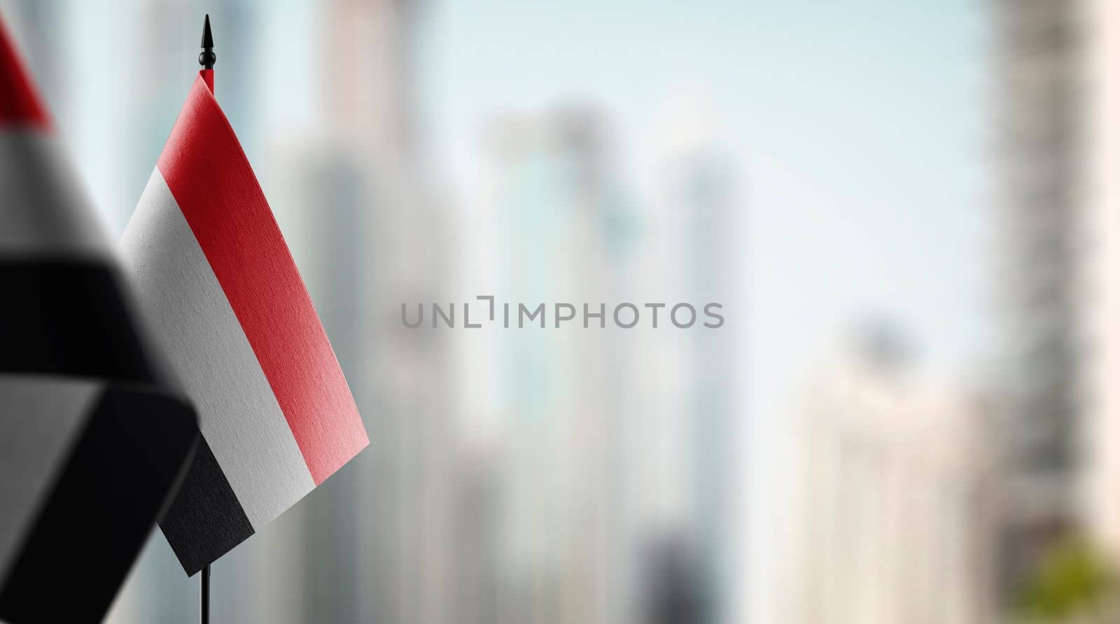 Small flags of the Yemen on an abstract blurry background by butenkow