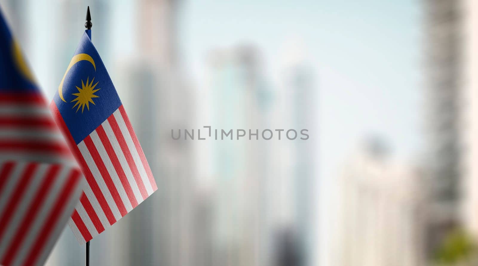 Small flags of the Malaysia on an abstract blurry background.