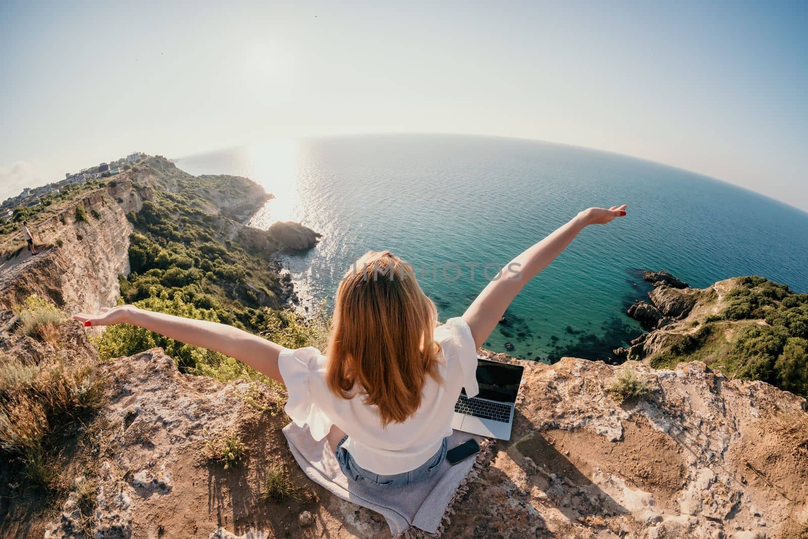 Woman sea laptop. Business woman in yellow hat working on laptop by sea. Close up on hands of pretty lady typing on computer outdoors summer day. Freelance, digital nomad, travel and holidays concept.