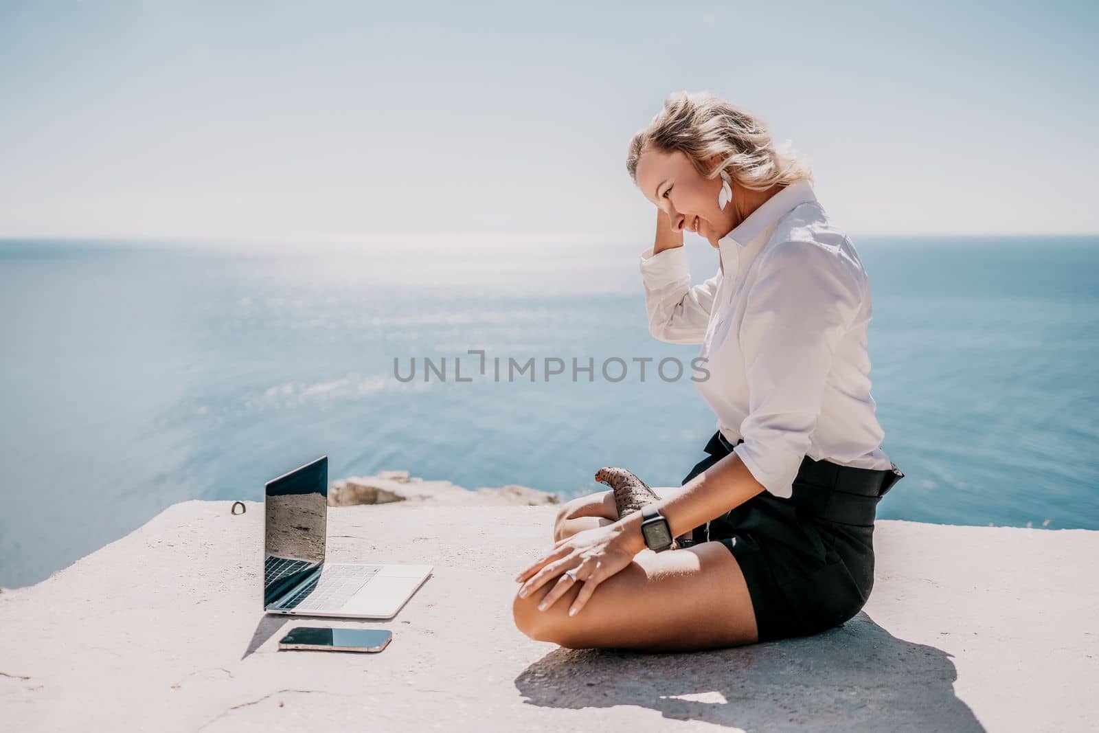 Woman sea laptop yoga. Business woman freelancer in yoga pose working over blue sea beach at laptop and meditates. Girl relieves stress from work. Freelance, digital nomad, travel and holidays concept by panophotograph