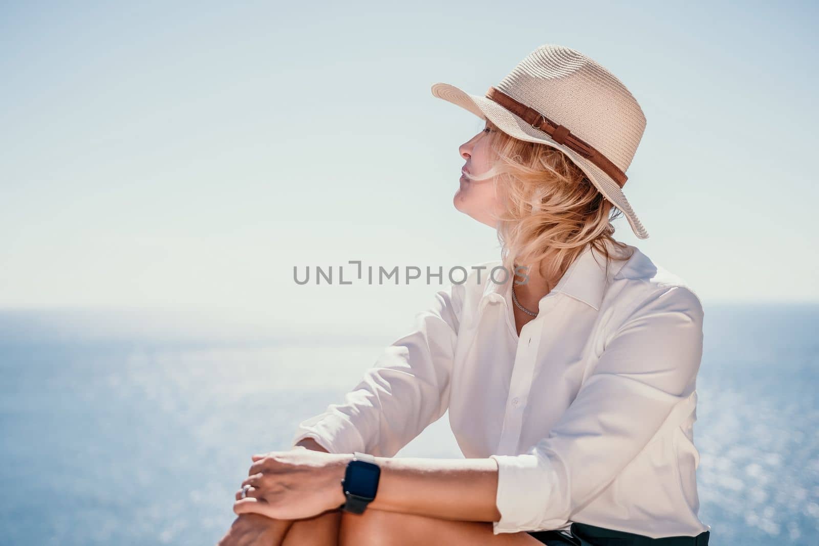 Woman sea laptop. Business woman in yellow hat freelancer with laptop working over blue sea beach. Girl relieves stress from work. Freelance, digital nomad, travel and holidays concept by panophotograph