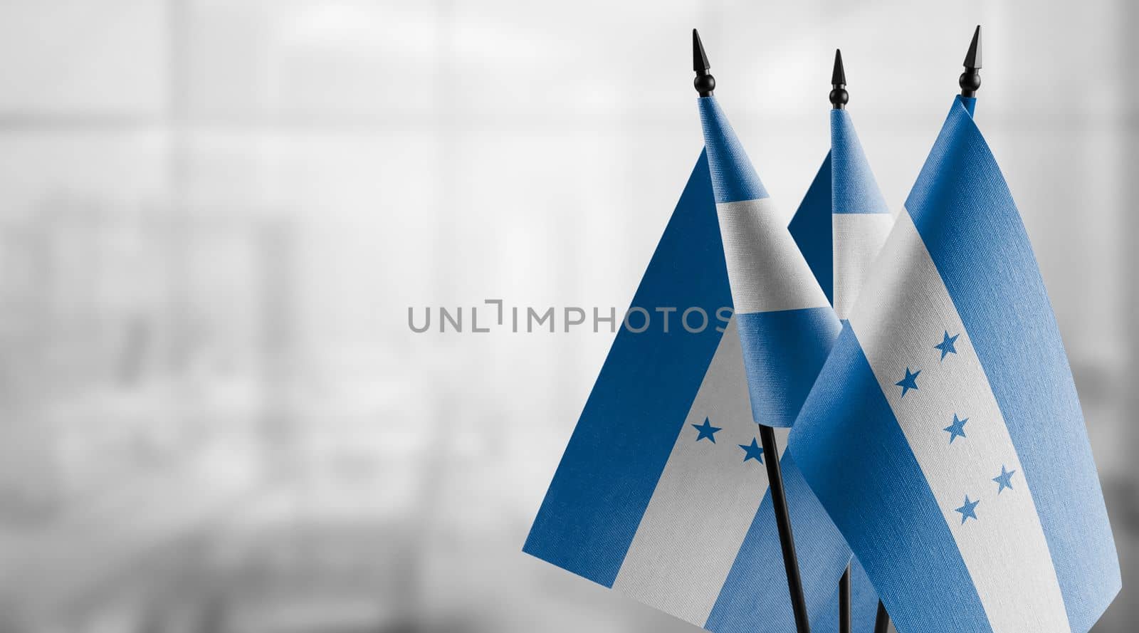 Small flags of the Honduras on an abstract blurry background by butenkow