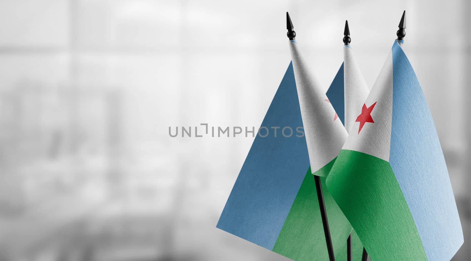 Small flags of the Djibouti on an abstract blurry background.