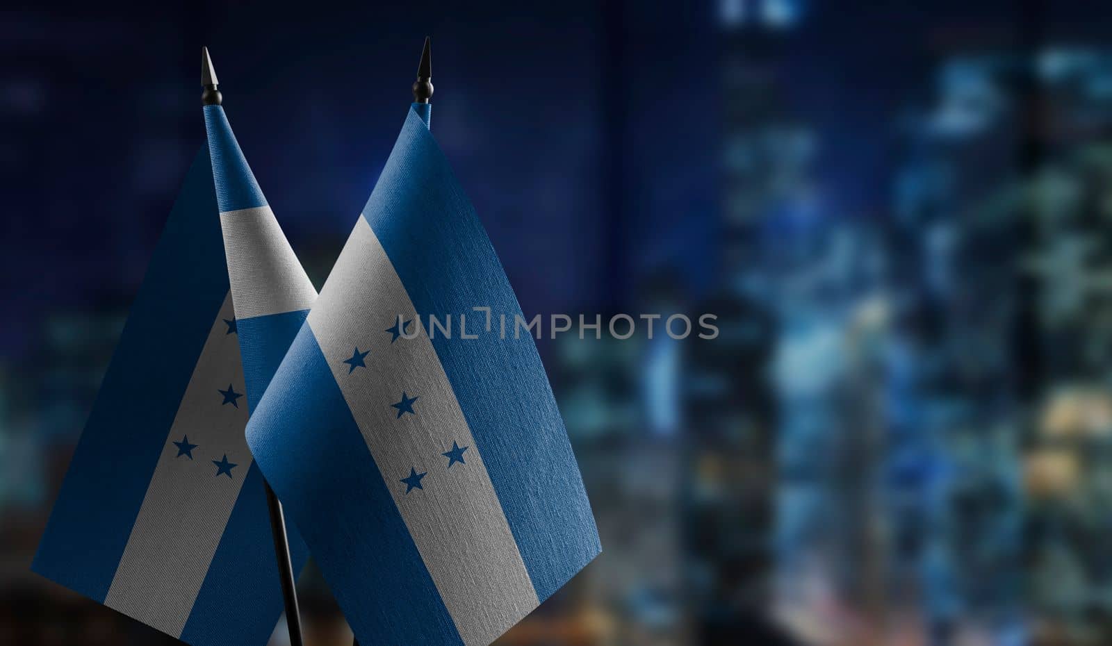 Small flags of the Honduras on an abstract blurry background.
