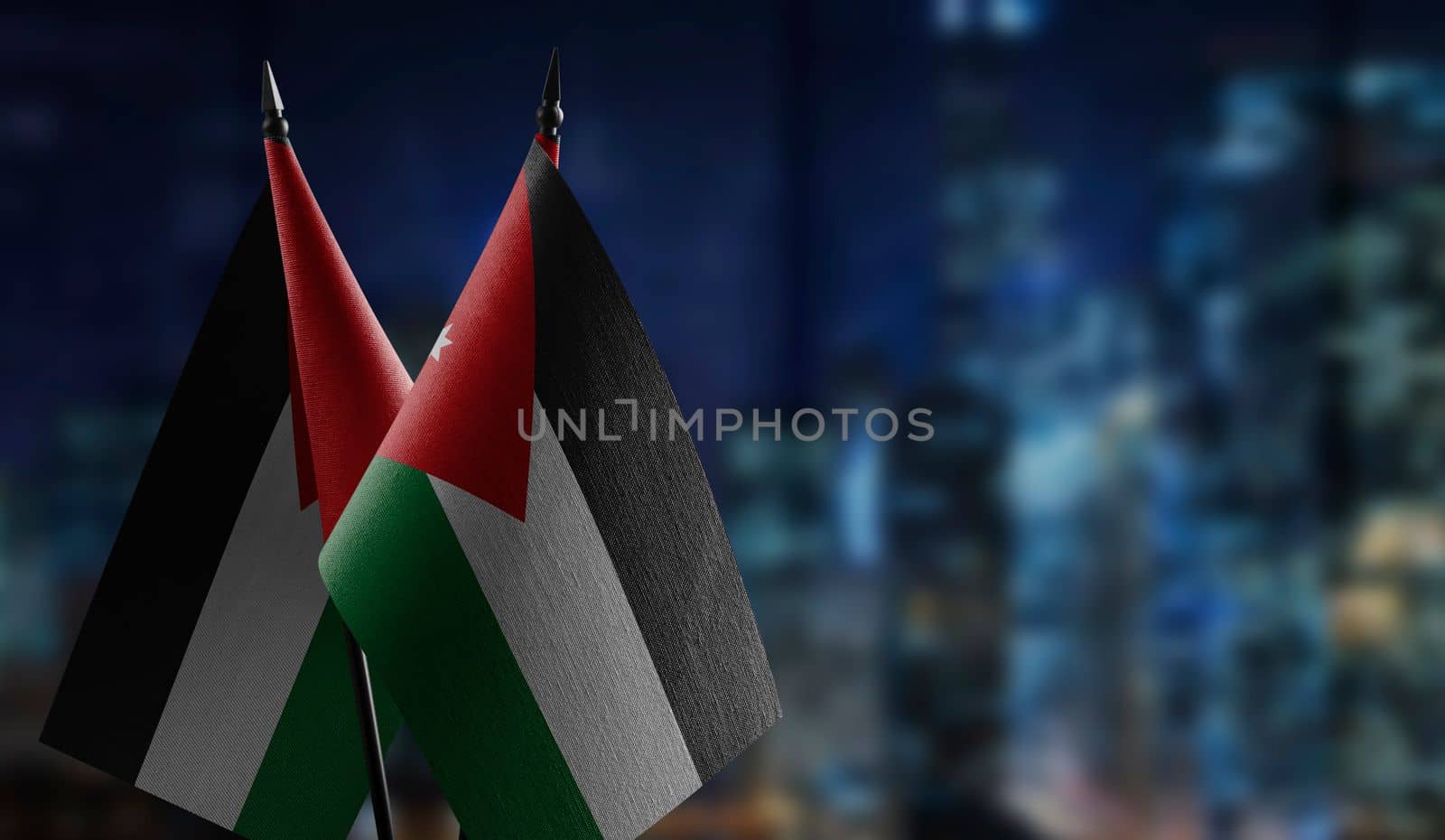 Small flags of the Jordan on an abstract blurry background.