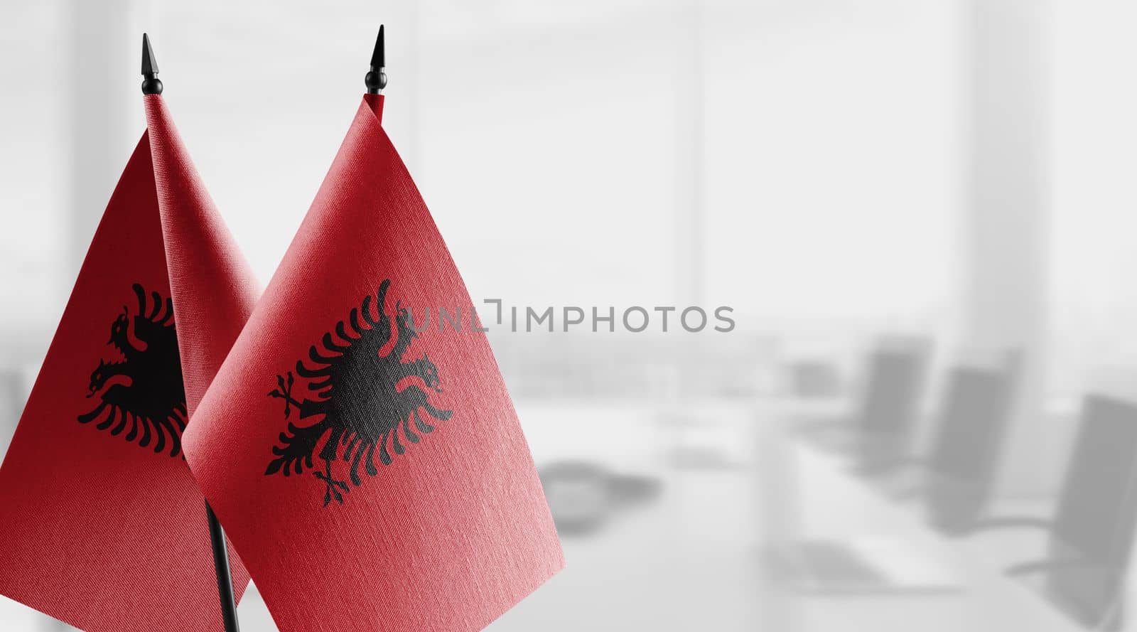 A small Albania flag on an abstract blurry background.