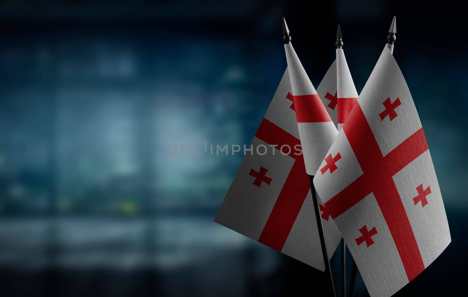A small Georgia flag on an abstract blurry background by butenkow