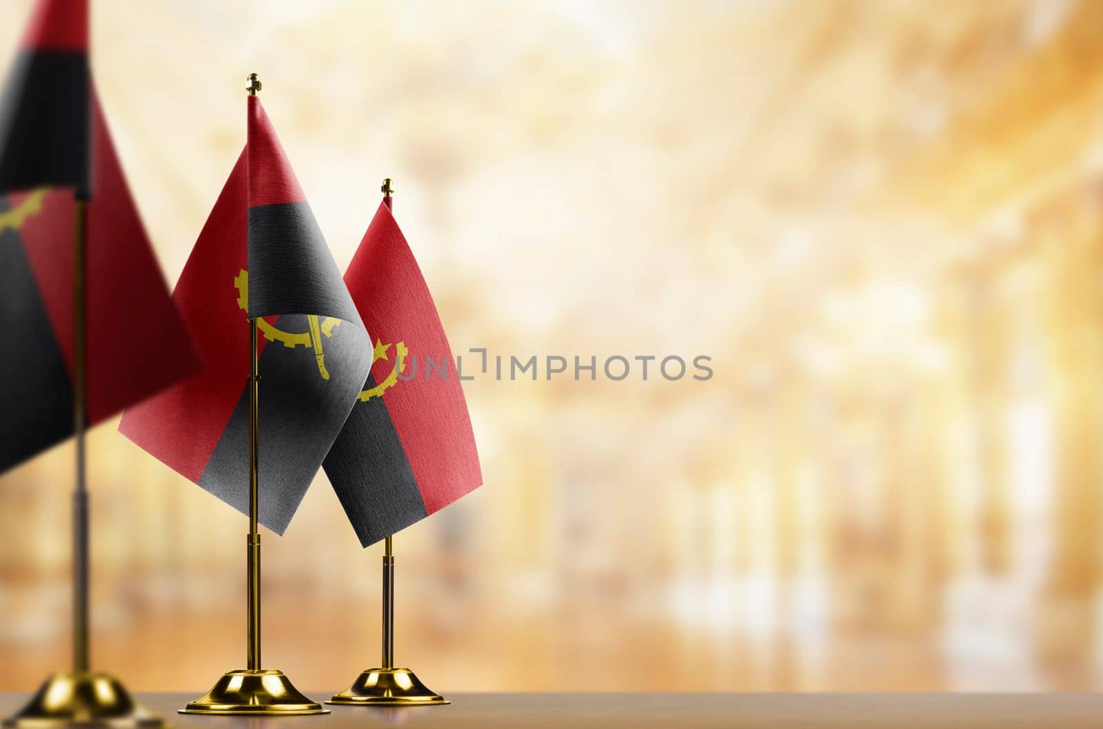 A small Angola flag on an abstract blurry background by butenkow